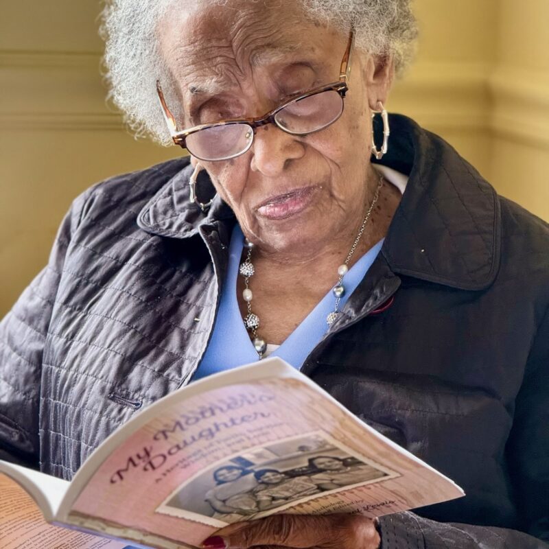 Black woman reading "My Mother's Daughter"