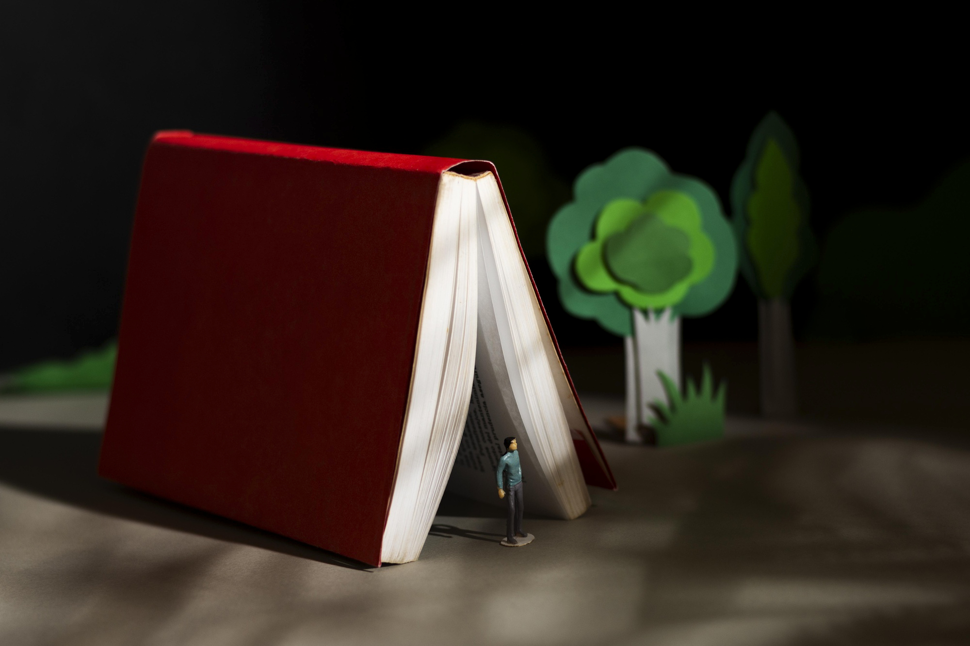 Figurine standing under a book as if it were a tent