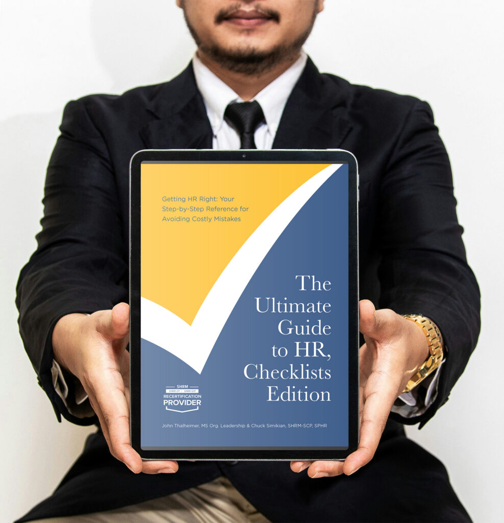 Mockup of man holding an eBook of "The Ultimate Guide to HR, Checklist Edition."